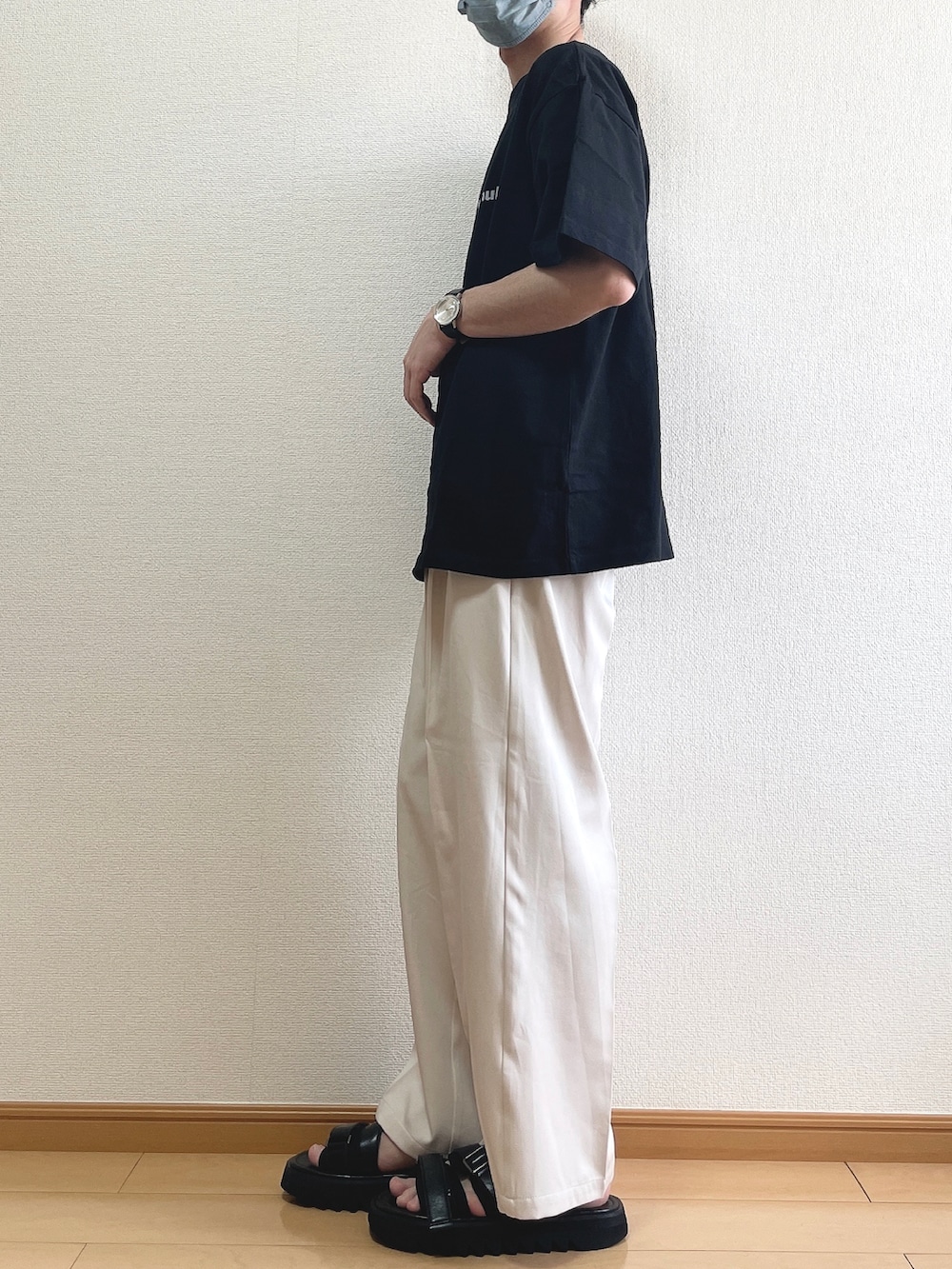 ブラック系のTシャツ/カットソー、ベージュ系のスラックス、ブラック系のサンダルを着用したメンズの夏コーディネートの3枚目の写真