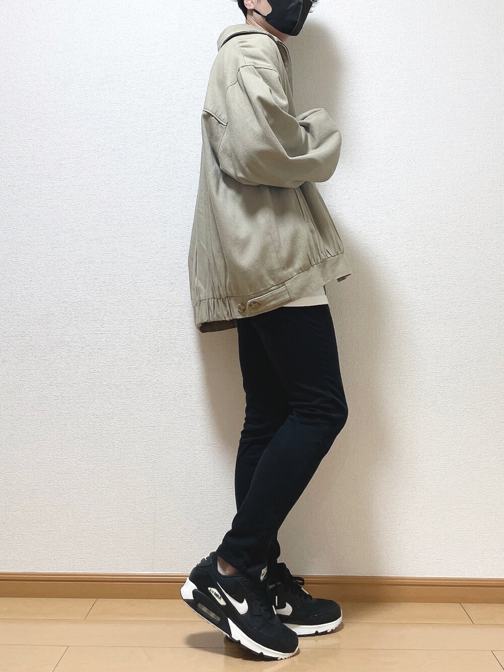 ベージュ系のブルゾン、ホワイト系のTシャツ/カットソー、ブラック系のデニムパンツを着用したメンズの秋コーディネートの2枚目の写真