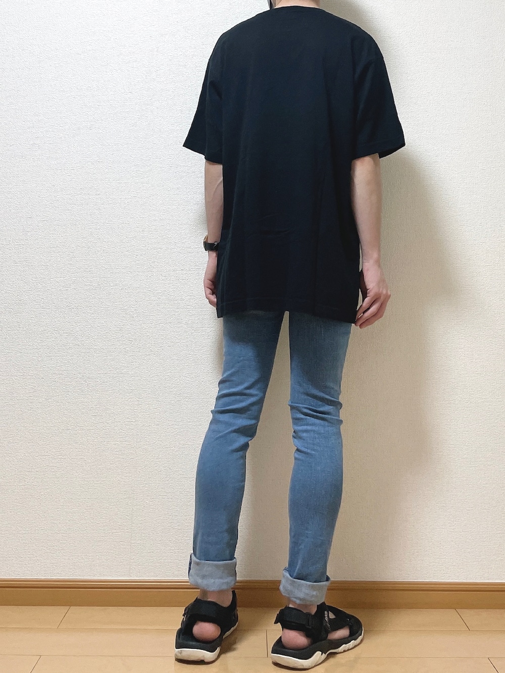 ブラック系のTシャツ/カットソー、ブルー系のデニムパンツ、ブラック系のサンダルを着用したメンズの夏コーディネートの4枚目の写真