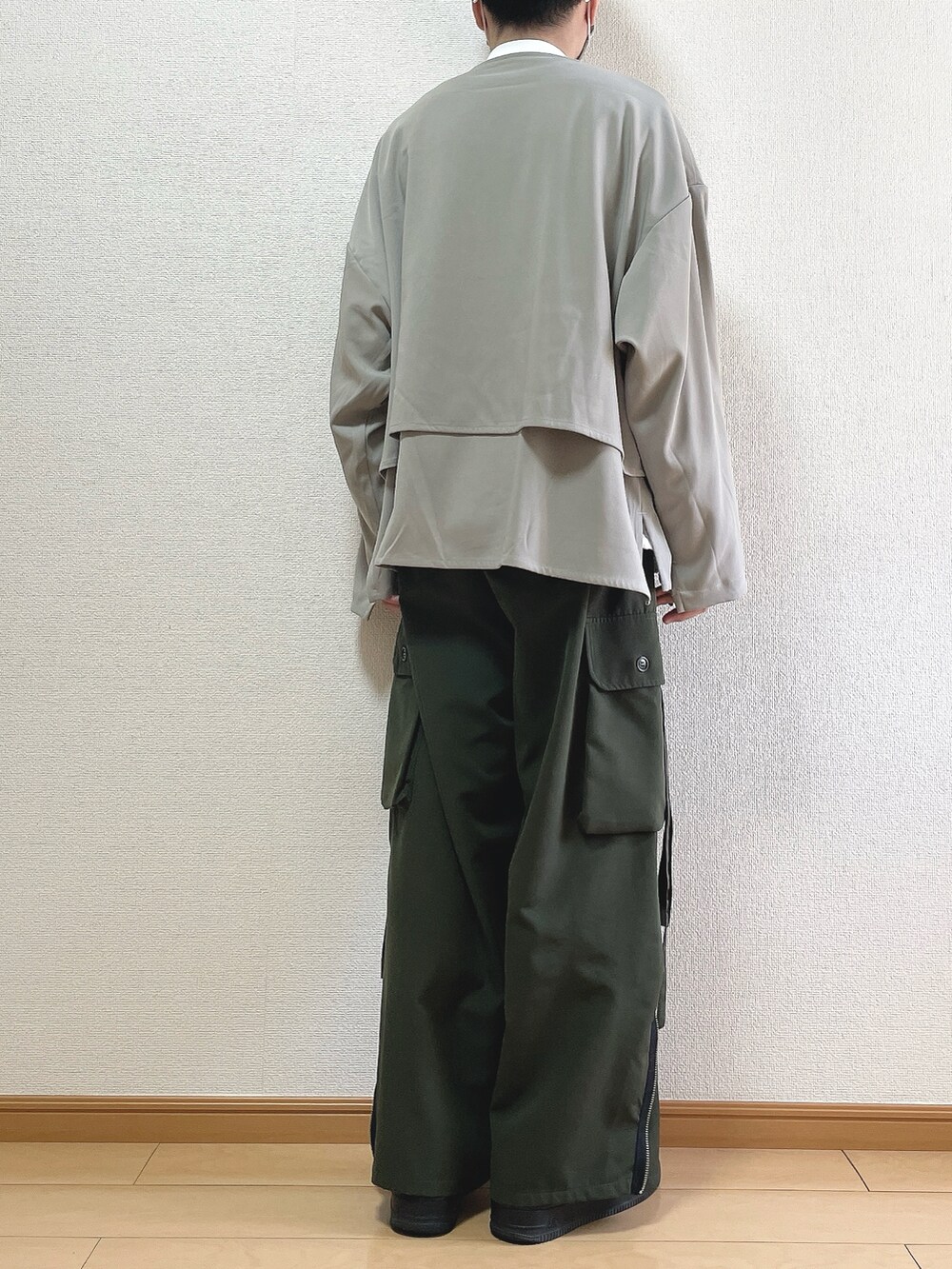 グレー系のブルゾン、ホワイト系のTシャツ/カットソー、グリーン系のカーゴパンツを着用したメンズの春コーディネートの4枚目の写真