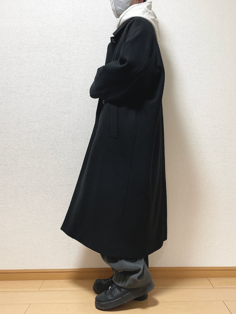 ブラック系のステンカラーコート、グレー系のパーカー、グレー系のTシャツ/カットソーを着用したメンズの冬コーディネートの2枚目の写真