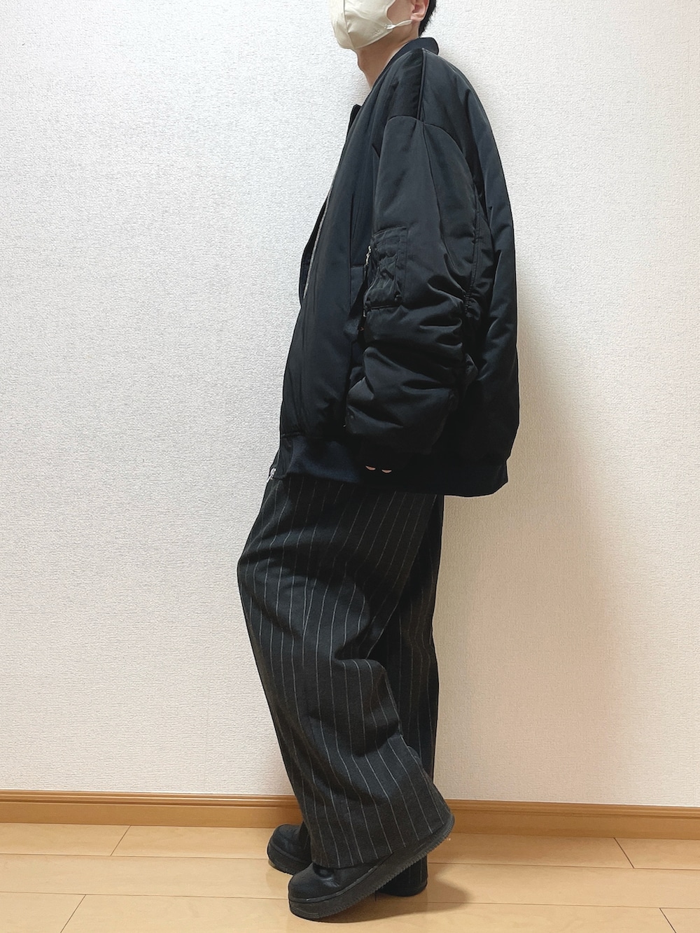 ブラック系のMA-1、ブラウン系のニット/セーター、ブラック系のパンツを着用したメンズの冬コーディネートの3枚目の写真