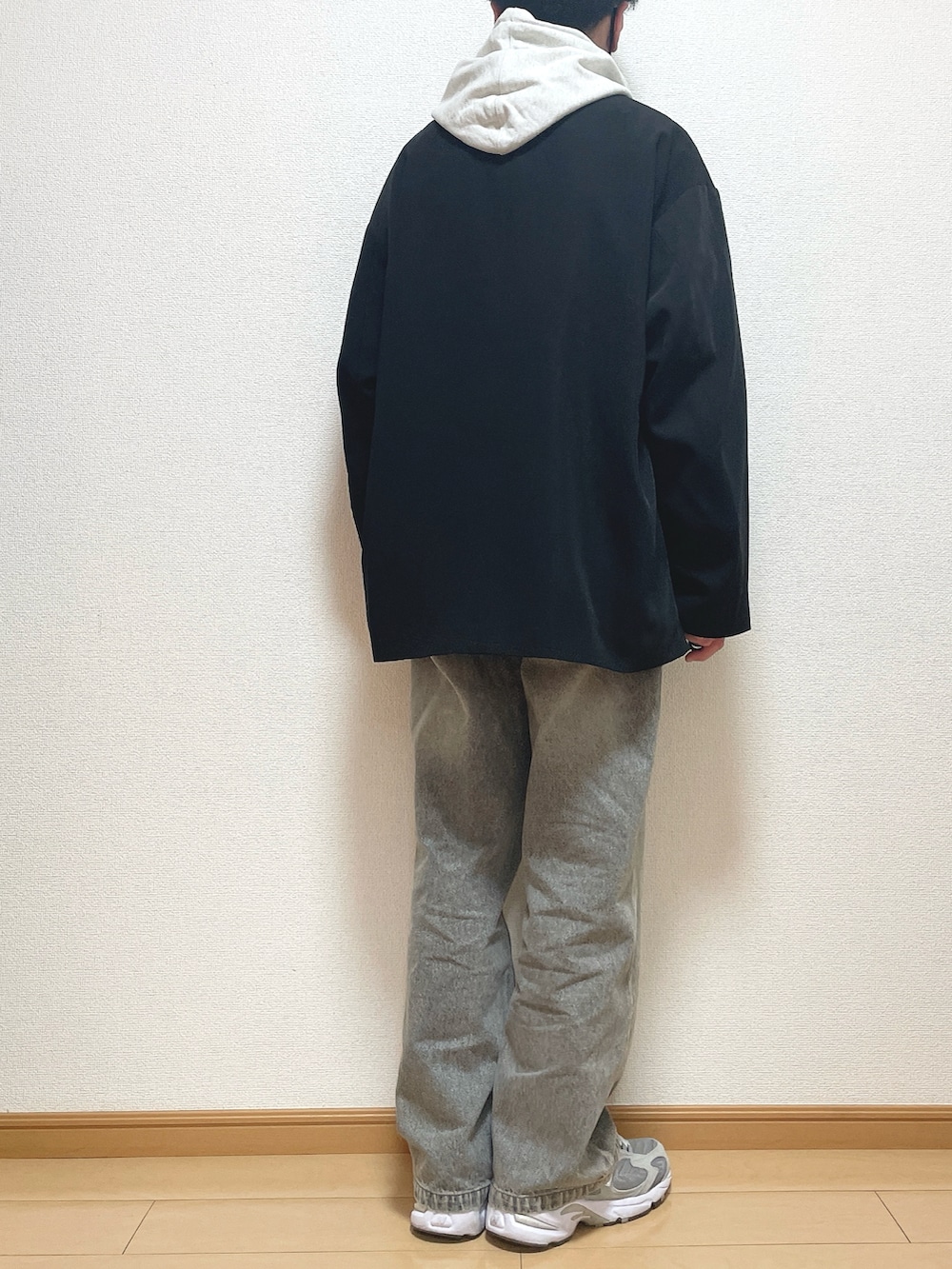 ブラック系のテーラードジャケット、グレー系のパーカー、ブラック系のデニムパンツを着用したメンズの冬コーディネートの4枚目の写真