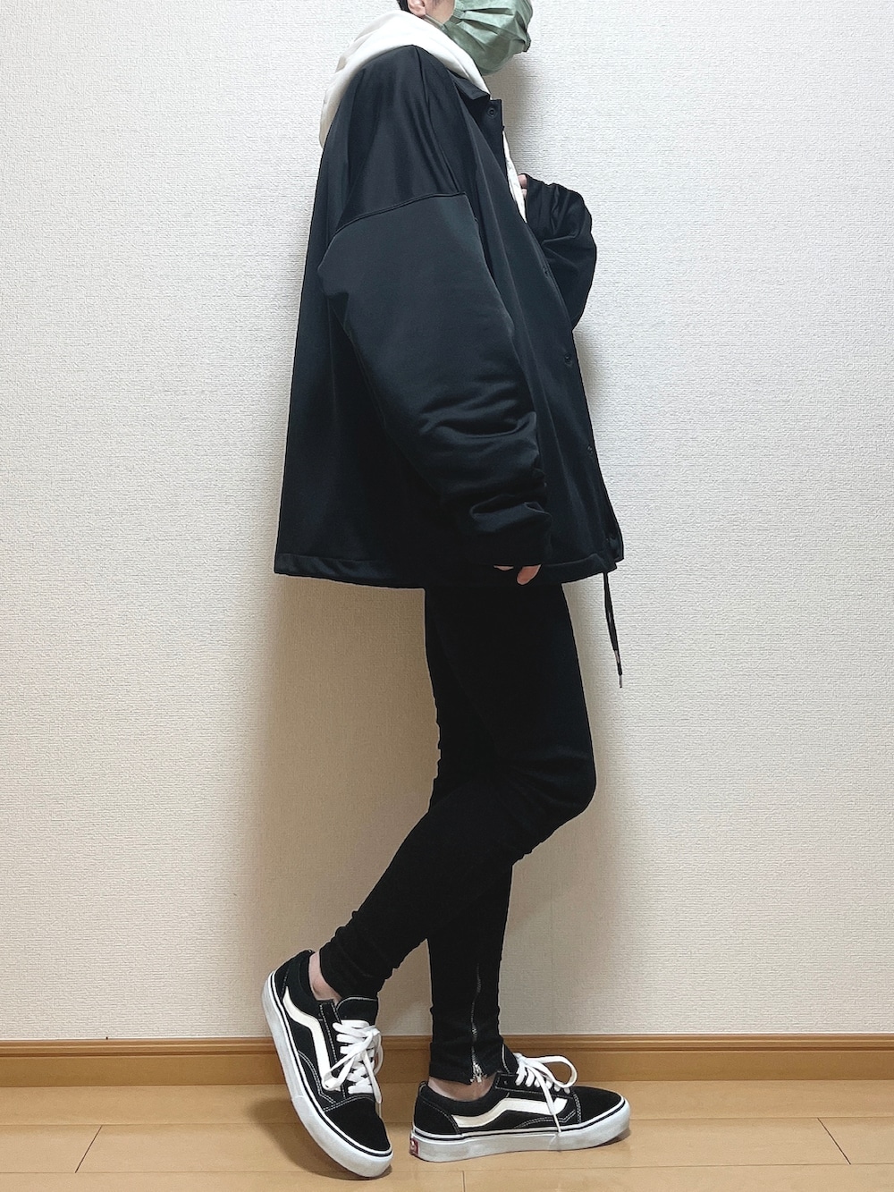 ブラック系のブルゾン、ホワイト系のパーカー、ブラウン系のTシャツ/カットソーを着用したメンズの冬コーディネートの2枚目の写真