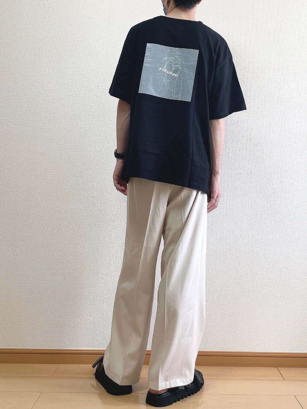ブラック系のTシャツ/カットソー、ベージュ系のスラックス、ブラック系のサンダルを着用したメンズの夏コーディネートの4枚目の写真