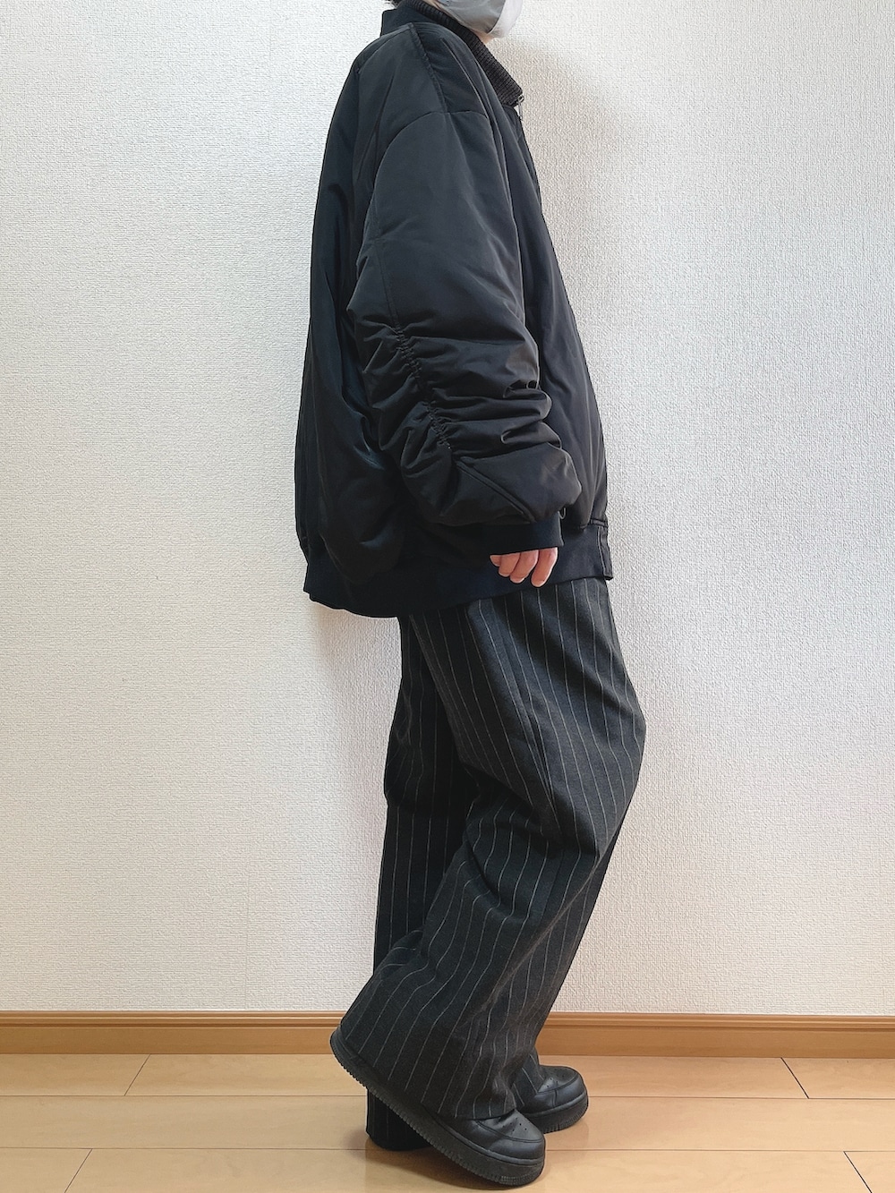 ブラック系のMA-1、グレー系のニット/セーター、ブラック系のパンツを着用したメンズの冬コーディネートの3枚目の写真