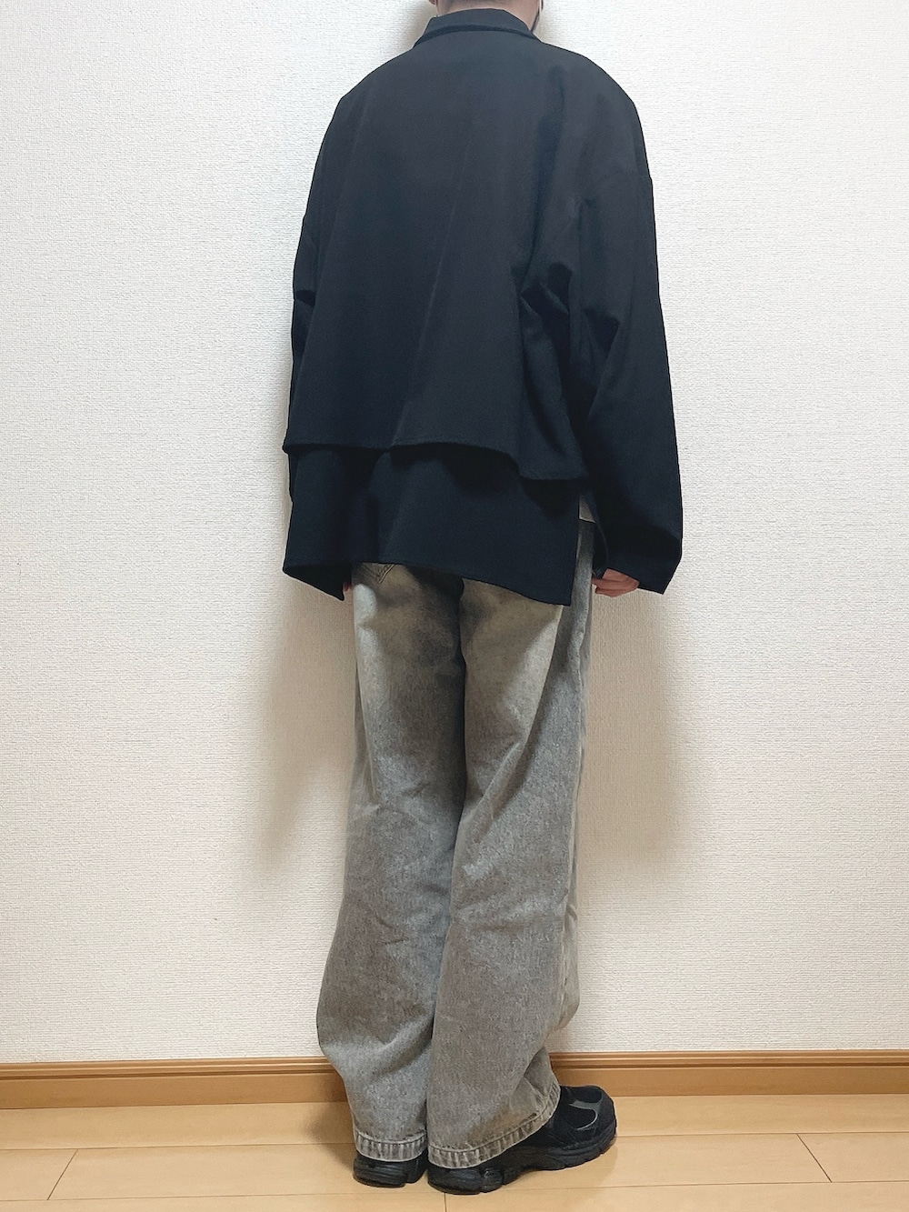 ブラック系のブルゾン、ホワイト系のTシャツ/カットソー、ブルー系のデニムパンツを着用したメンズの春コーディネートの4枚目の写真