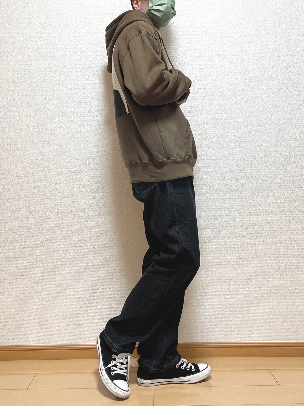 ブラウン系のパーカー、ホワイト系のTシャツ/カットソー、ブラック系のデニムパンツを着用したメンズの冬コーディネートの3枚目の写真