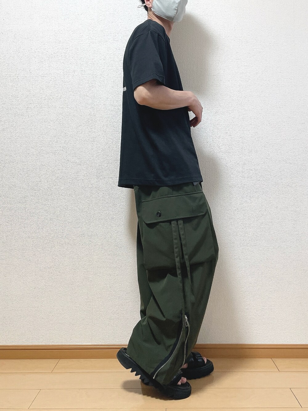 ブラック系のTシャツ/カットソー、グリーン系のカーゴパンツ、ブラック系のサンダルを着用したメンズの春コーディネートの2枚目の写真