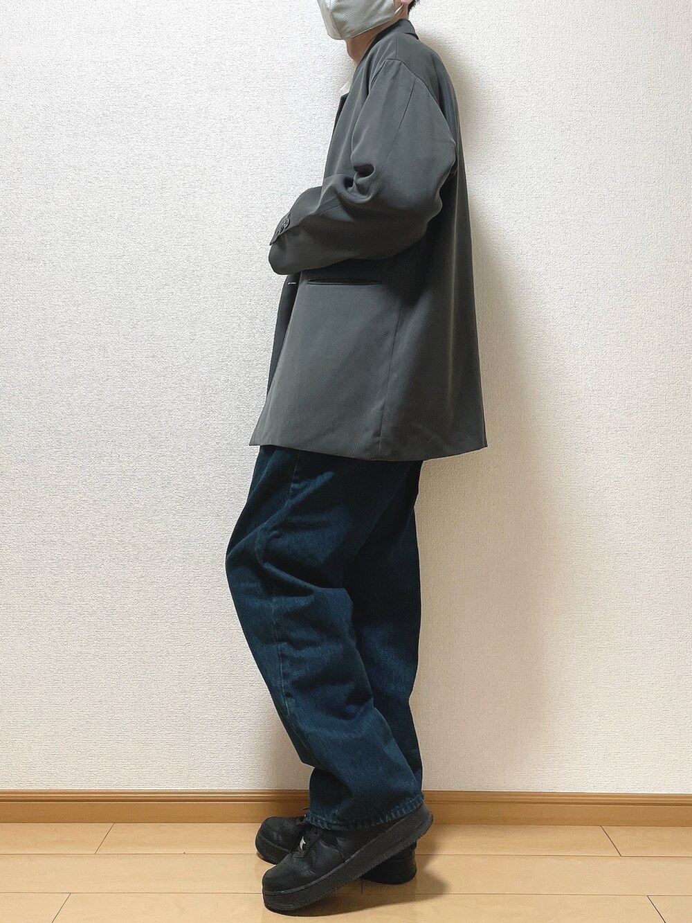 グレー系のテーラードジャケット、ホワイト系のスウェット、ブルー系のデニムパンツを着用したメンズの冬コーディネートの3枚目の写真