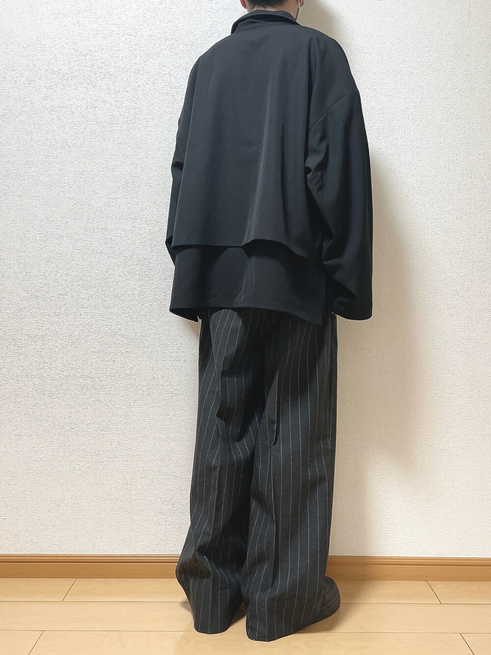 ブラック系のブルゾン、ホワイト系のTシャツ/カットソー、ブラック系のパンツを着用したメンズの春コーディネートの4枚目の写真