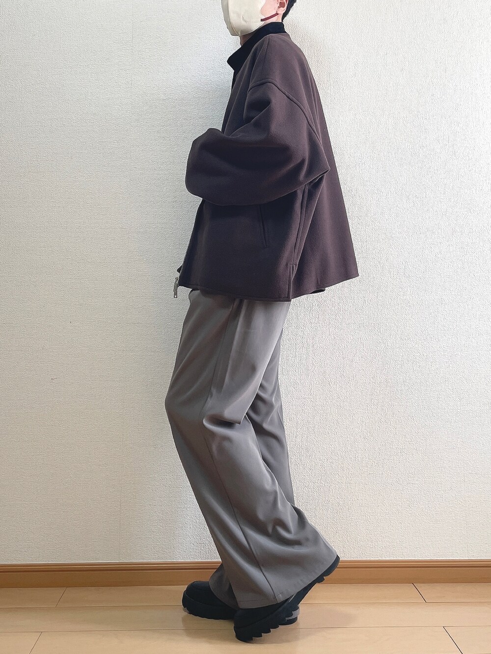 レッド系のブルゾン、ホワイト系のTシャツ/カットソー、ブラウン系のスラックスを着用したメンズの春コーディネートの3枚目の写真