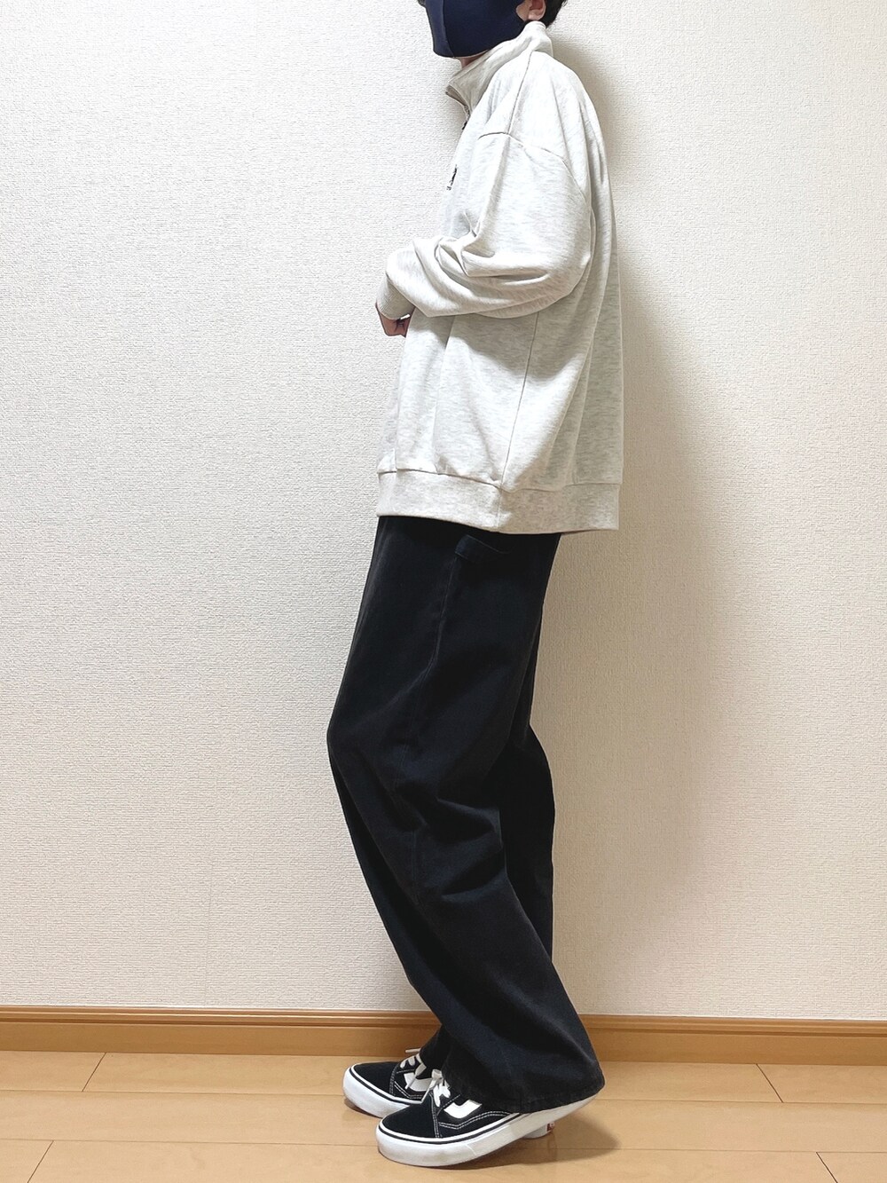 グレー系のスウェット、ブラック系のデニムパンツ、ブラック系のスニーカーを着用したメンズの秋コーディネートの3枚目の写真