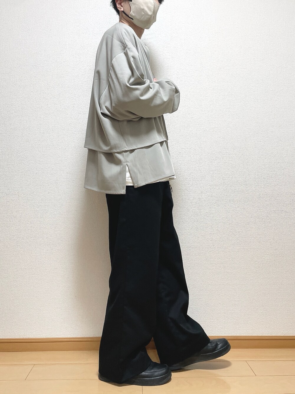 グレー系のブルゾン、ホワイト系のTシャツ/カットソー、ブラック系のスラックスを着用したメンズの春コーディネートの2枚目の写真