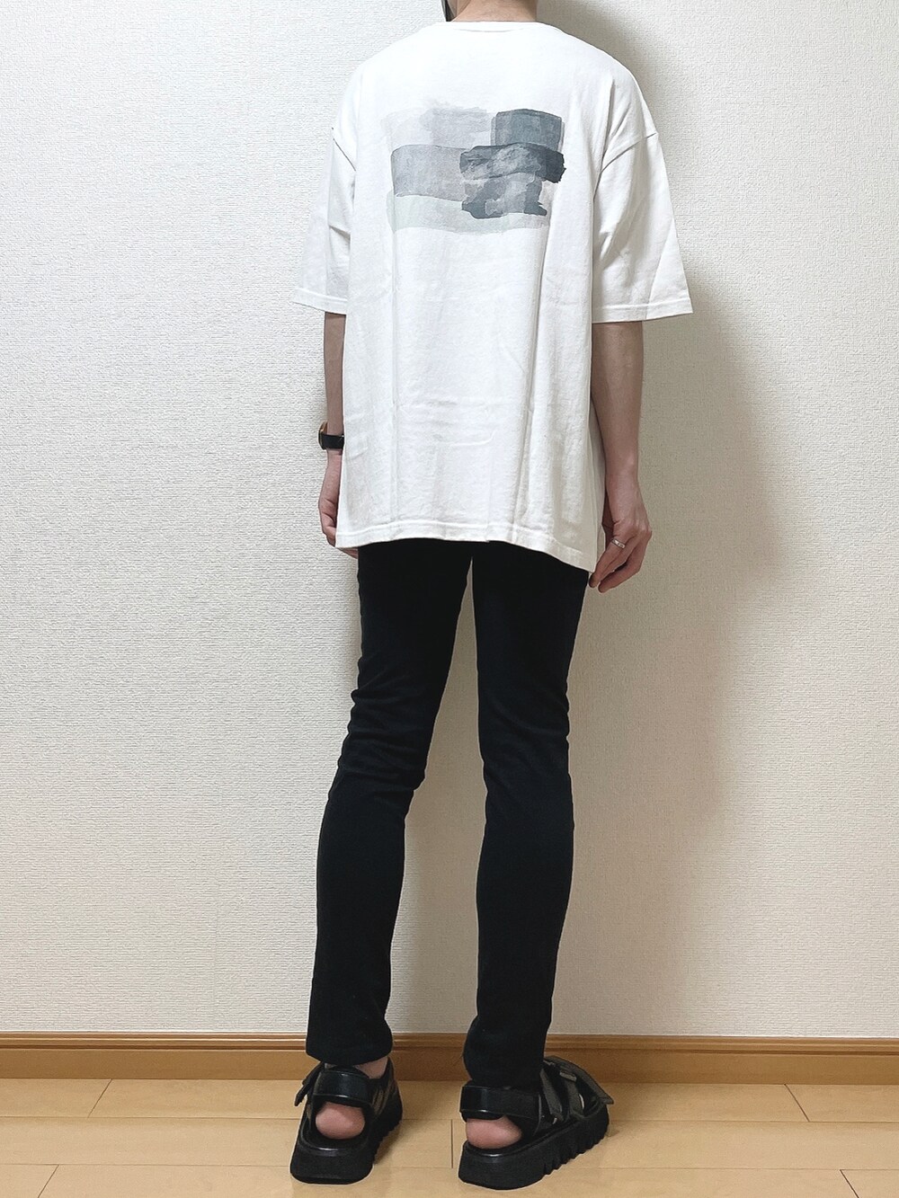 グリーン系のTシャツ/カットソー、ブラック系のデニムパンツ、ブラック系のサンダルを着用したメンズの夏コーディネートの4枚目の写真