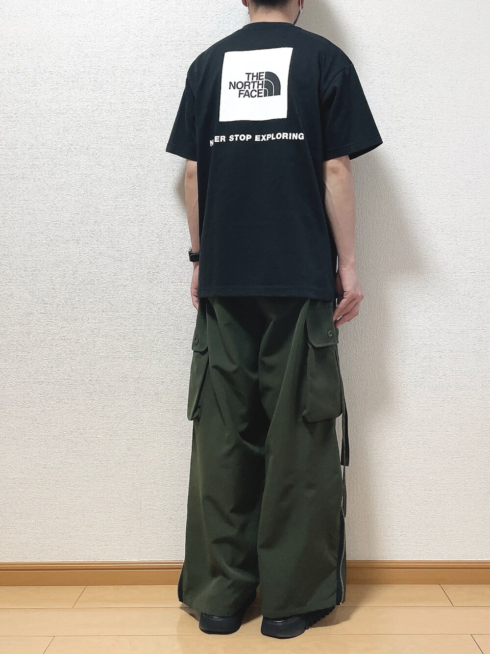 ブラック系のTシャツ/カットソー、グリーン系のカーゴパンツ、ブラック系のサンダルを着用したメンズの春コーディネートの4枚目の写真