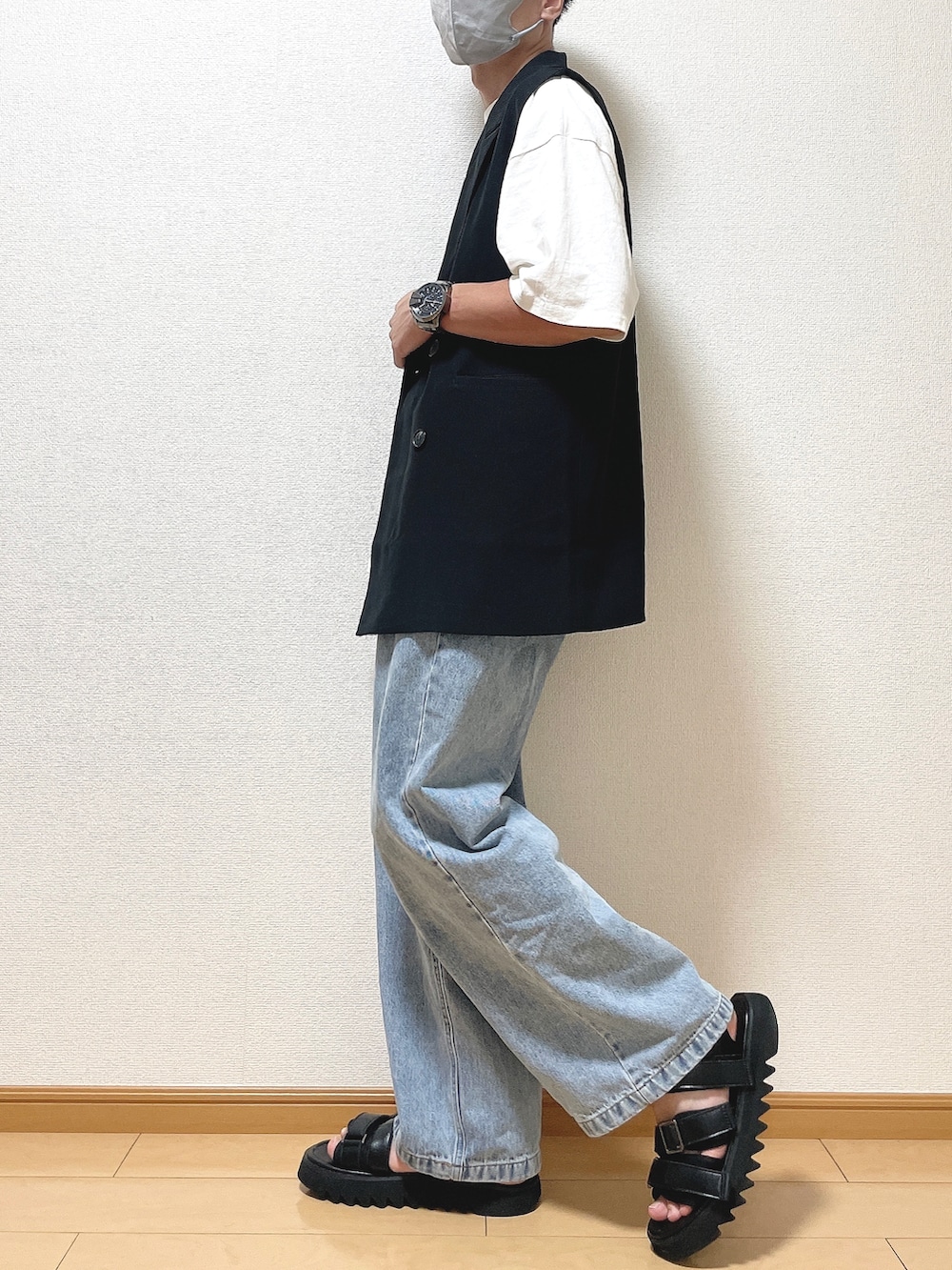 ブラック系のベスト、ホワイト系のTシャツ/カットソー、ブルー系のデニムパンツを着用したメンズの夏コーディネートの3枚目の写真