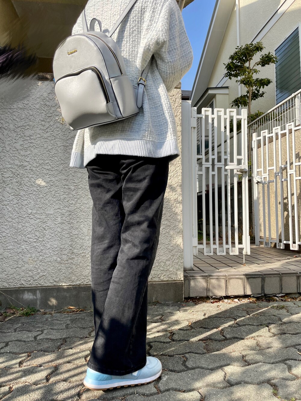 ブルー系のニット/セーター、ブラック系のデニムパンツ、ブルー系のスニーカーを着用したレディースの春コーディネートの2枚目の写真