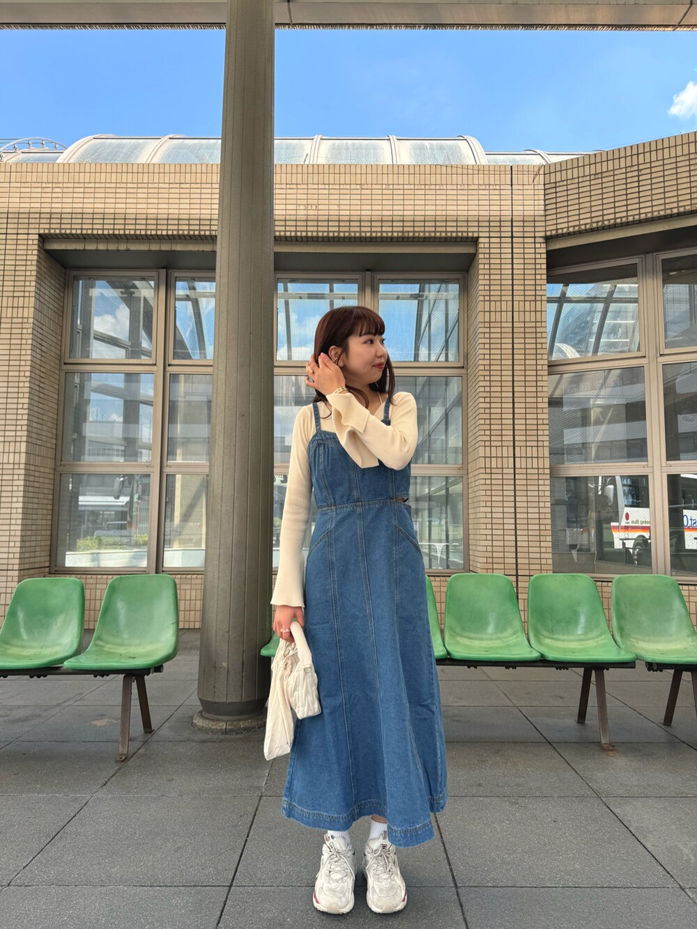 ブルー系のワンピース、ベージュ系のニット/セーター、ベージュ系のバッグを着用したレディースの夏コーディネートの3枚目の写真