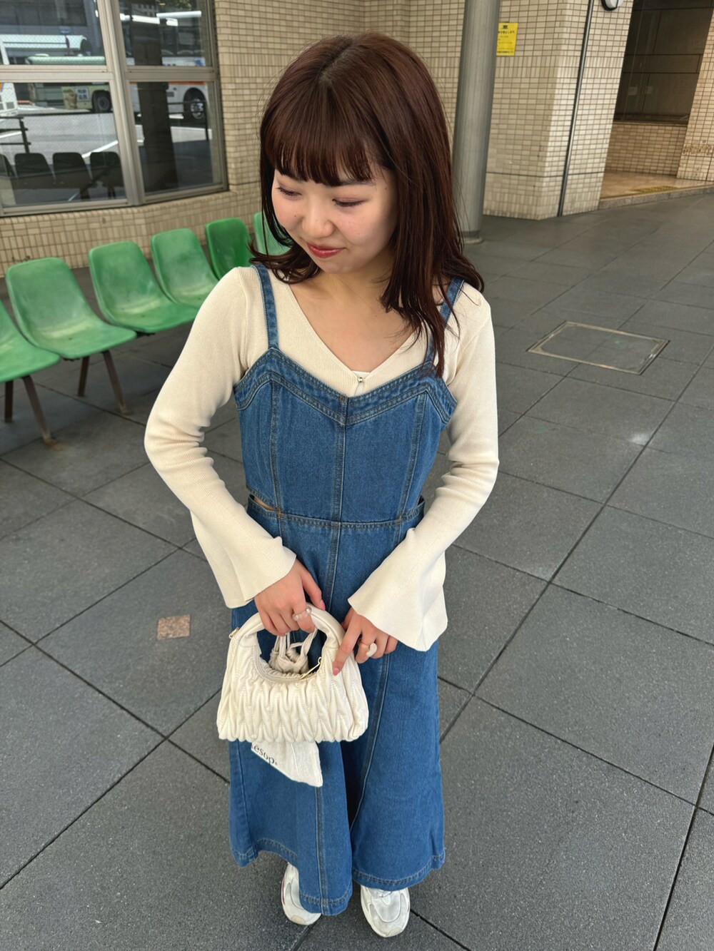 ブルー系のワンピース、ベージュ系のニット/セーター、ベージュ系のバッグを着用したレディースの夏コーディネートの2枚目の写真