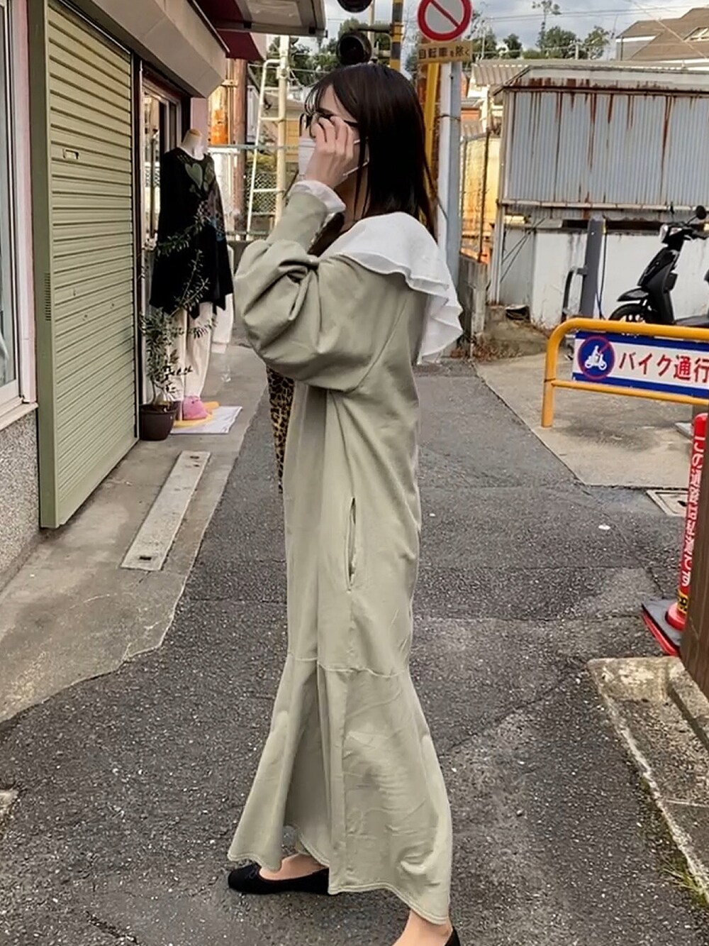 グリーン系のワンピース、ホワイト系のシャツ/ブラウスを着用したレディースの秋コーディネートの2枚目の写真