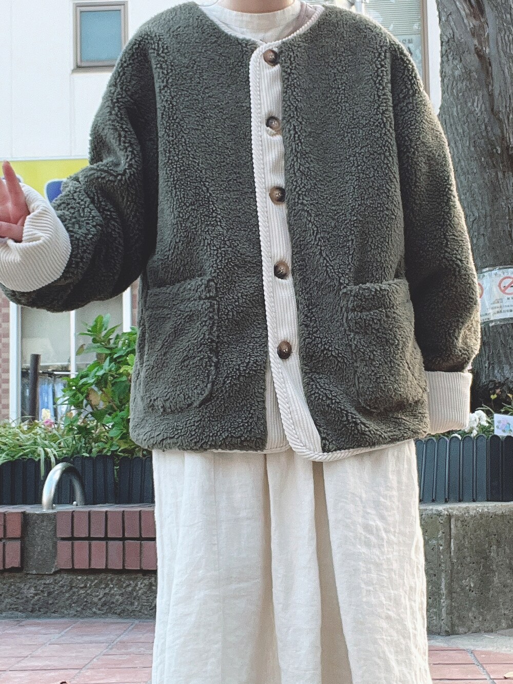 グリーン系のジャケット/アウター、ホワイト系のワンピース、ベージュ系のスラックスを着用したレディースの冬コーディネートの2枚目の写真