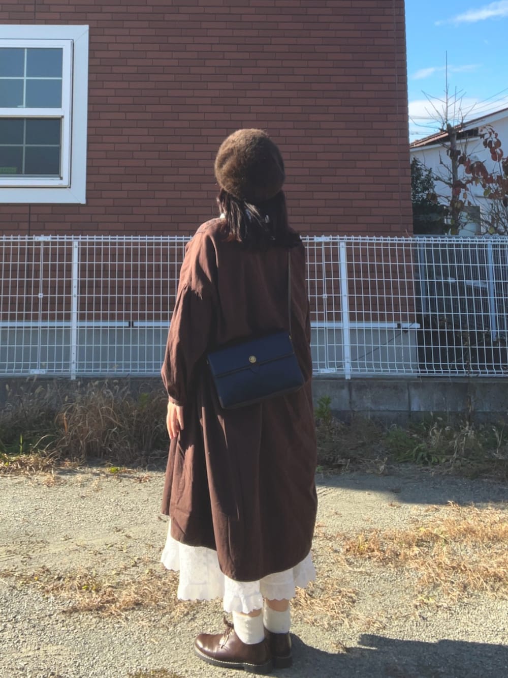 ブラウン系のその他シューズ、ホワイト系のスカート、ブラウン系のワンピース/ドレスを着用したレディースの冬コーディネートの3枚目の写真