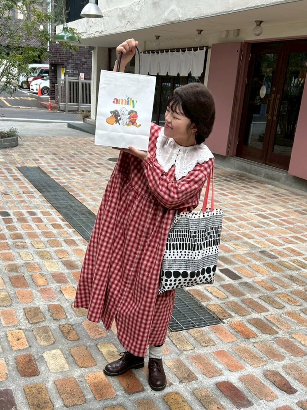 レッド系のワンピース、ブラウン系のその他シューズ、その他のトートバッグを着用したレディースの春コーディネートの4枚目の写真