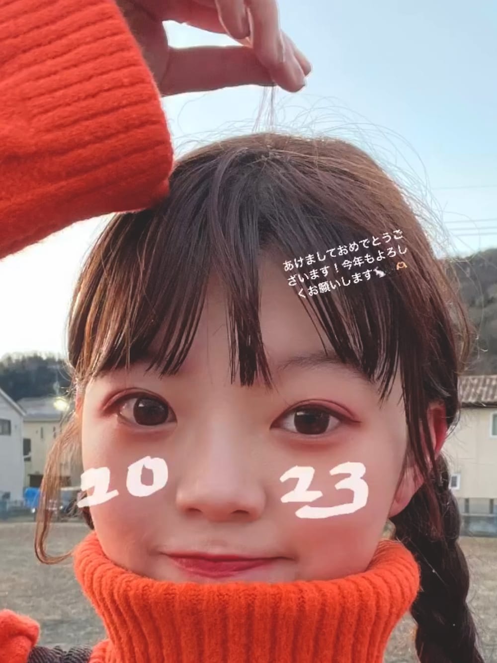 オレンジ系のニット/セーター、シルバー系のバレエシューズ、ブラック系のサロペット/オーバーオールを着用したレディースの冬コーディネートの3枚目の写真