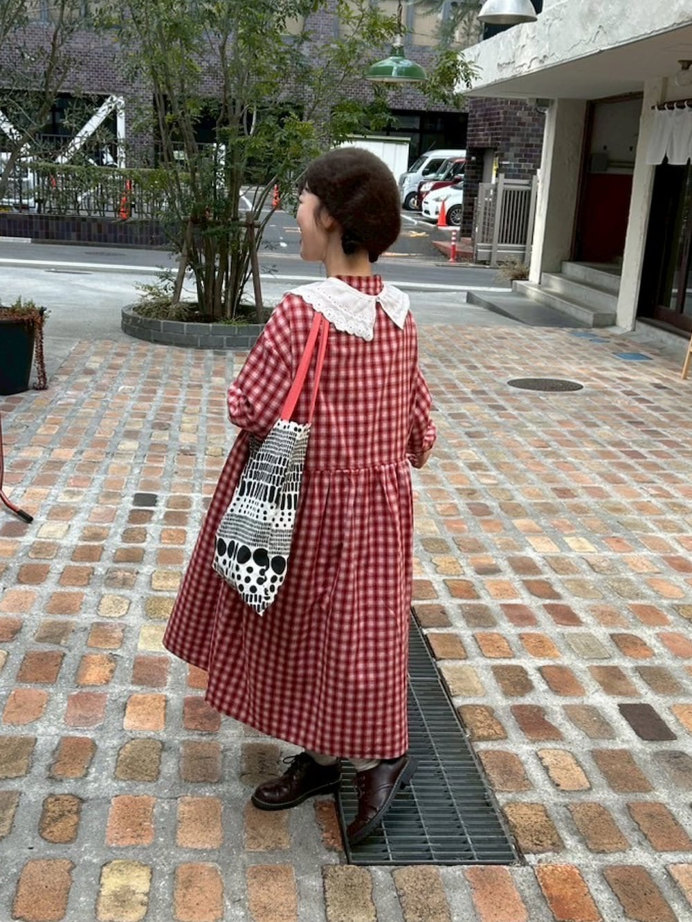 レッド系のワンピース、ブラウン系のその他シューズ、その他のトートバッグを着用したレディースの春コーディネートの3枚目の写真