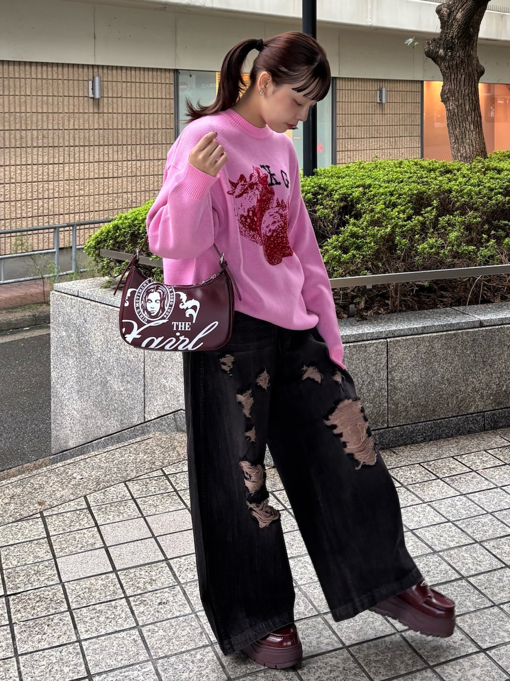 ピンク系のニット/セーター、ブラック系のデニムパンツ、レッド系のハンドバッグを着用したレディースの秋コーディネートの2枚目の写真