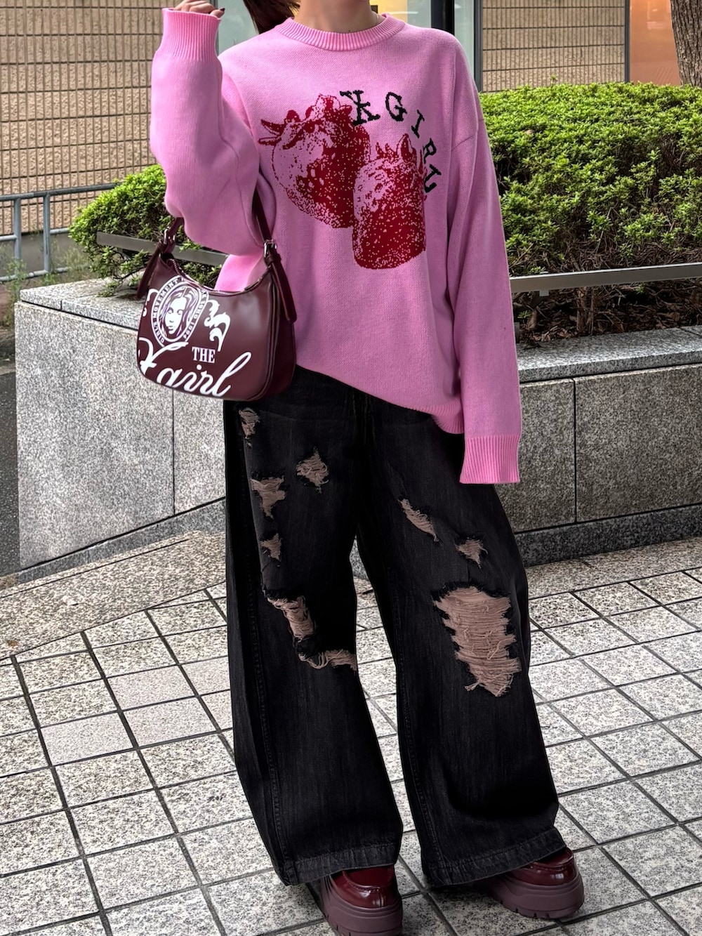 ピンク系のニット/セーター、ブラック系のデニムパンツ、レッド系のハンドバッグを着用したレディースの秋コーディネートの3枚目の写真