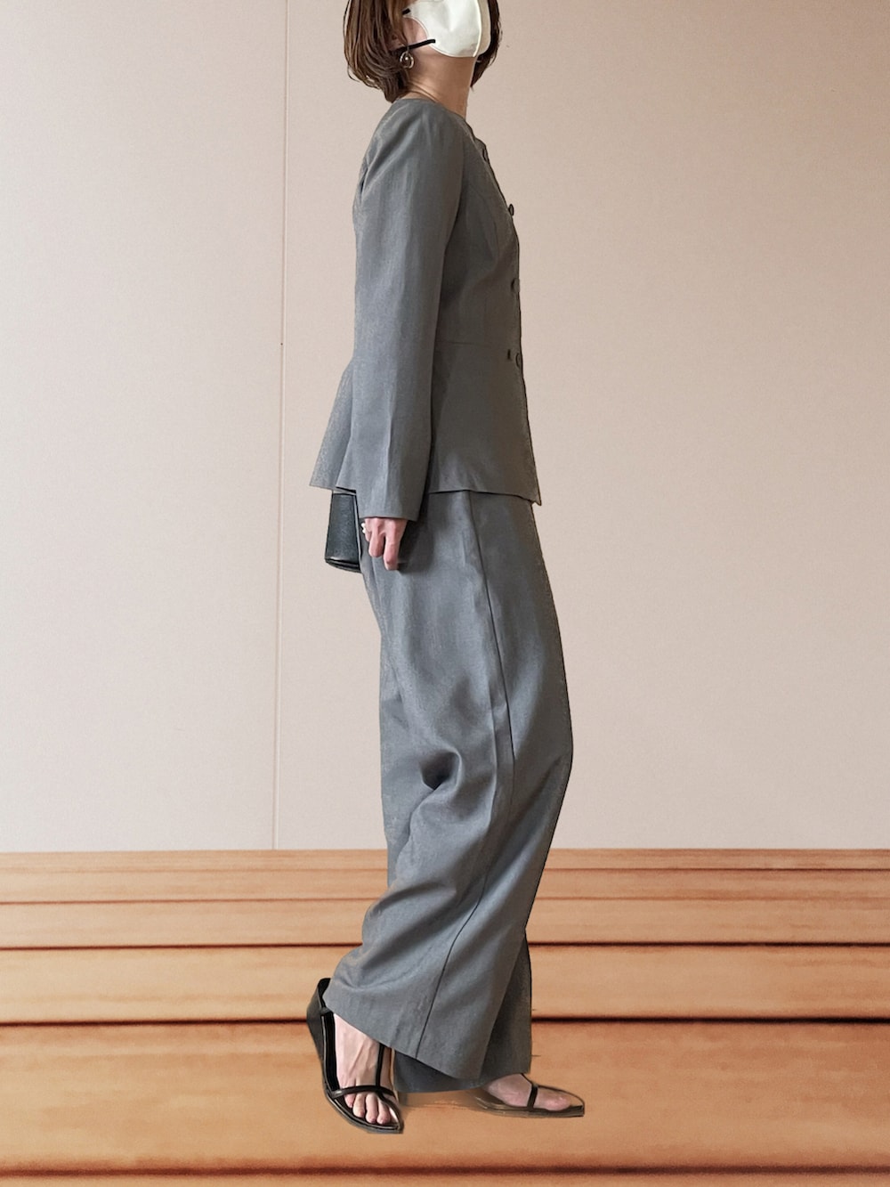 ブラック系のサンダル、ブラック系のショルダーバッグ、グレー系のスーツセットを着用したレディースの春コーディネートの2枚目の写真