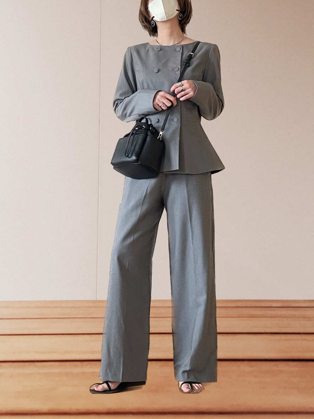 ブラック系のサンダル、ブラック系のショルダーバッグ、グレー系のスーツセットを着用したレディースの春コーディネートの4枚目の写真