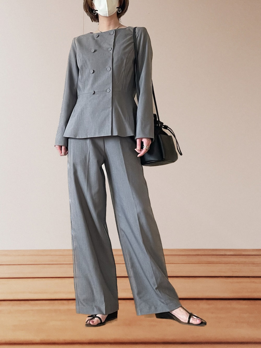 ブラック系のサンダル、ブラック系のショルダーバッグ、グレー系のスーツセットを着用したレディースの春コーディネートの3枚目の写真