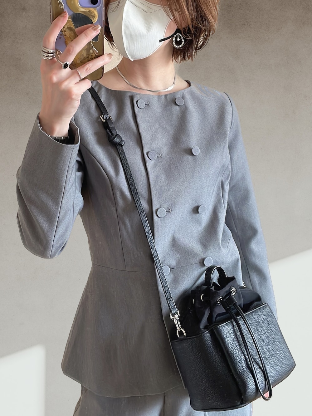 ブラック系のサンダル、ブラック系のショルダーバッグ、グレー系のスーツセットを着用したレディースの春コーディネートの5枚目の写真