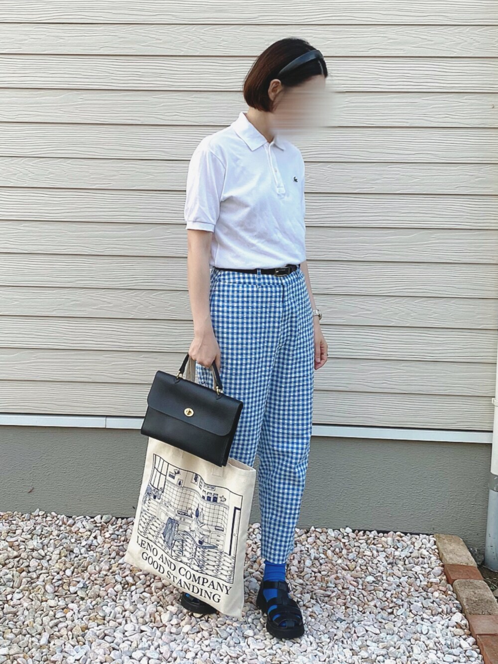 ホワイト系のポロシャツ、ブルー系のその他パンツ、ブラック系のショルダーバッグを着用したレディースの春コーディネートの2枚目の写真