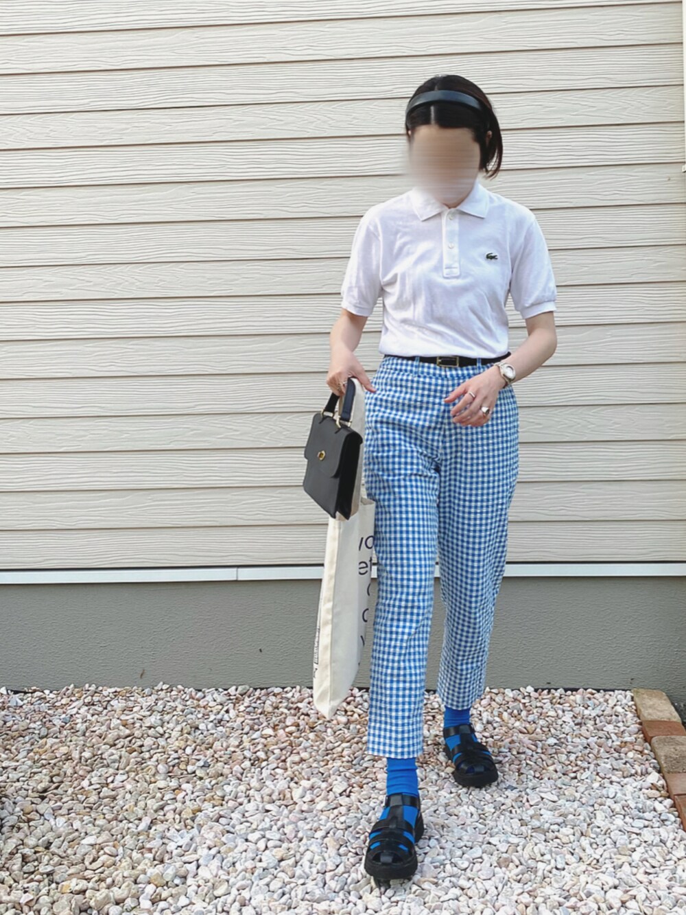 ホワイト系のポロシャツ、ブルー系のその他パンツ、ブラック系のショルダーバッグを着用したレディースの春コーディネートの5枚目の写真