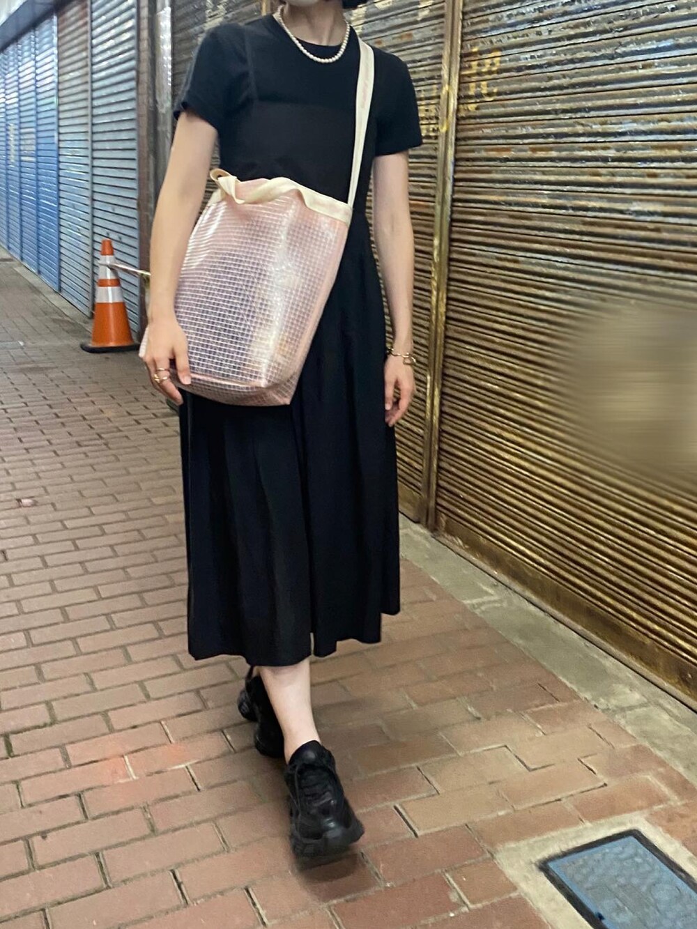 ピンク系のショルダーバッグ、ブラック系のTシャツ/カットソー、ブラック系のドレスを着用したレディースの夏コーディネートの2枚目の写真