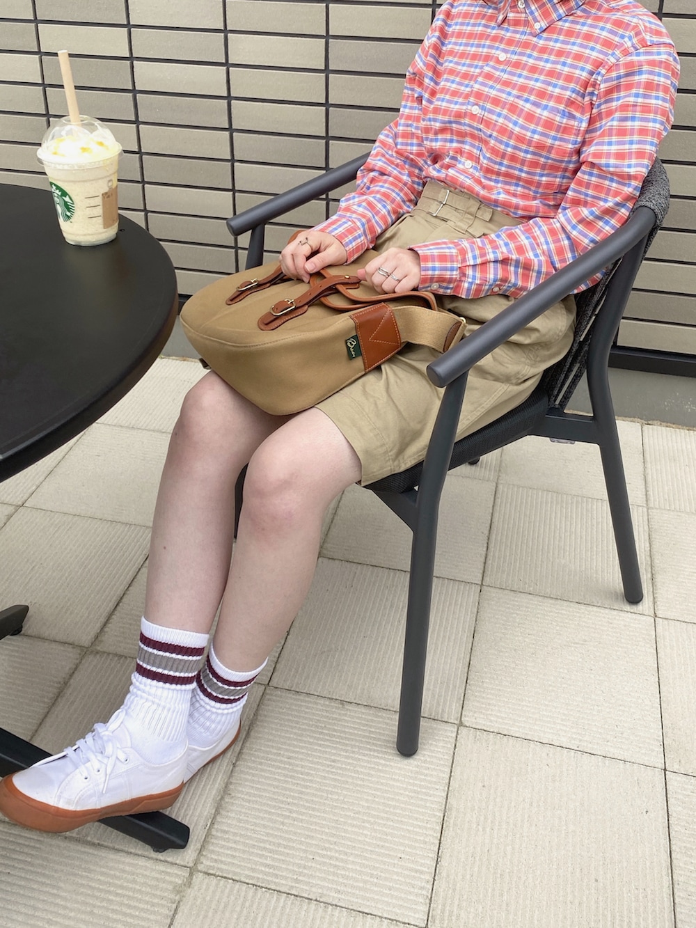ピンク系のシャツ/ブラウス、ベージュ系のパンツ、グリーン系のショルダーバッグを着用したレディースの夏コーディネートの2枚目の写真