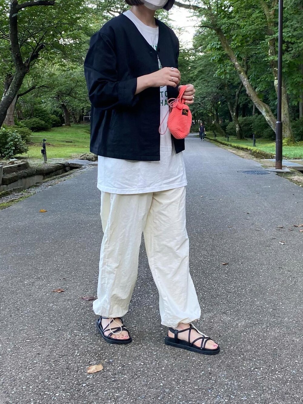 ホワイト系のTシャツ/カットソー、ホワイト系のパンツ、ブラック系のサンダルを着用したレディースの夏コーディネートの5枚目の写真