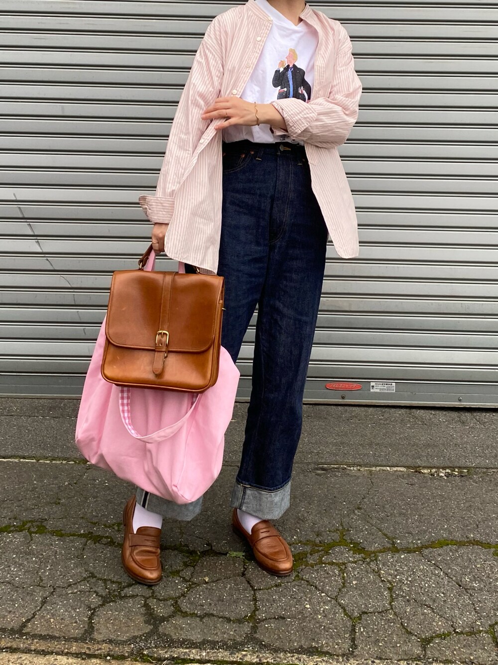 ピンク系のシャツ/ブラウス、ホワイト系のTシャツ/カットソー、ブルー系のデニムパンツを着用したレディースの秋コーディネートの2枚目の写真