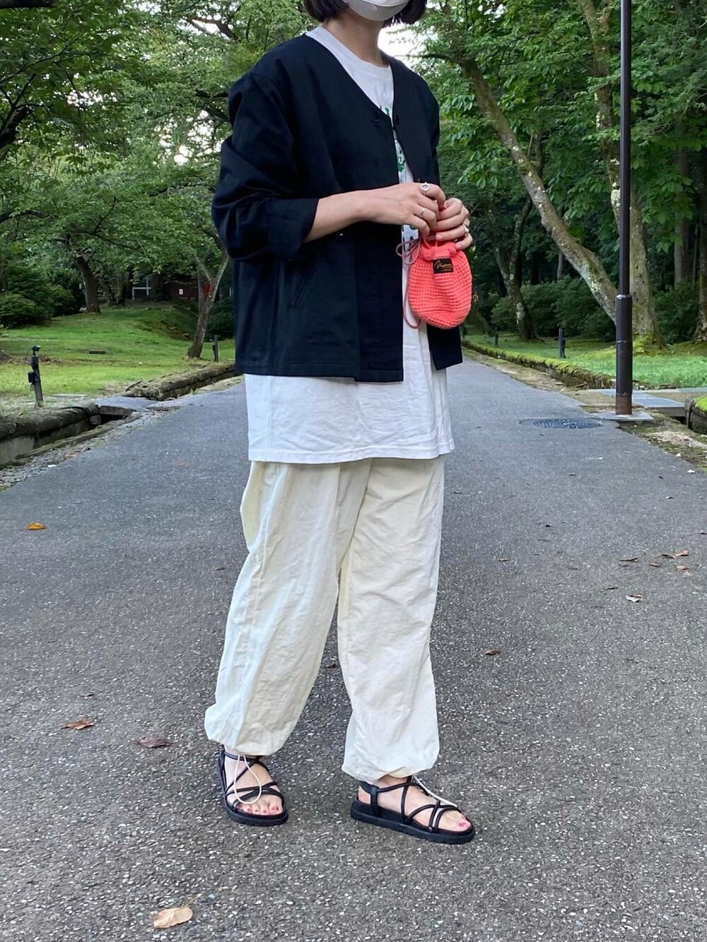 ホワイト系のTシャツ/カットソー、ホワイト系のパンツ、ブラック系のサンダルを着用したレディースの夏コーディネートの4枚目の写真