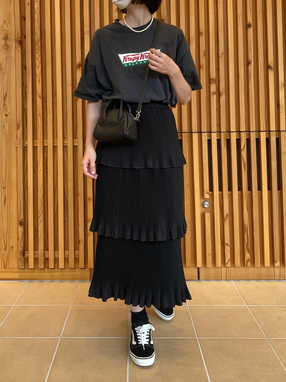 ブラック系のTシャツ/カットソー、ブラック系のスカート、ブラック系のスニーカーを着用したレディースの秋コーディネートの4枚目の写真