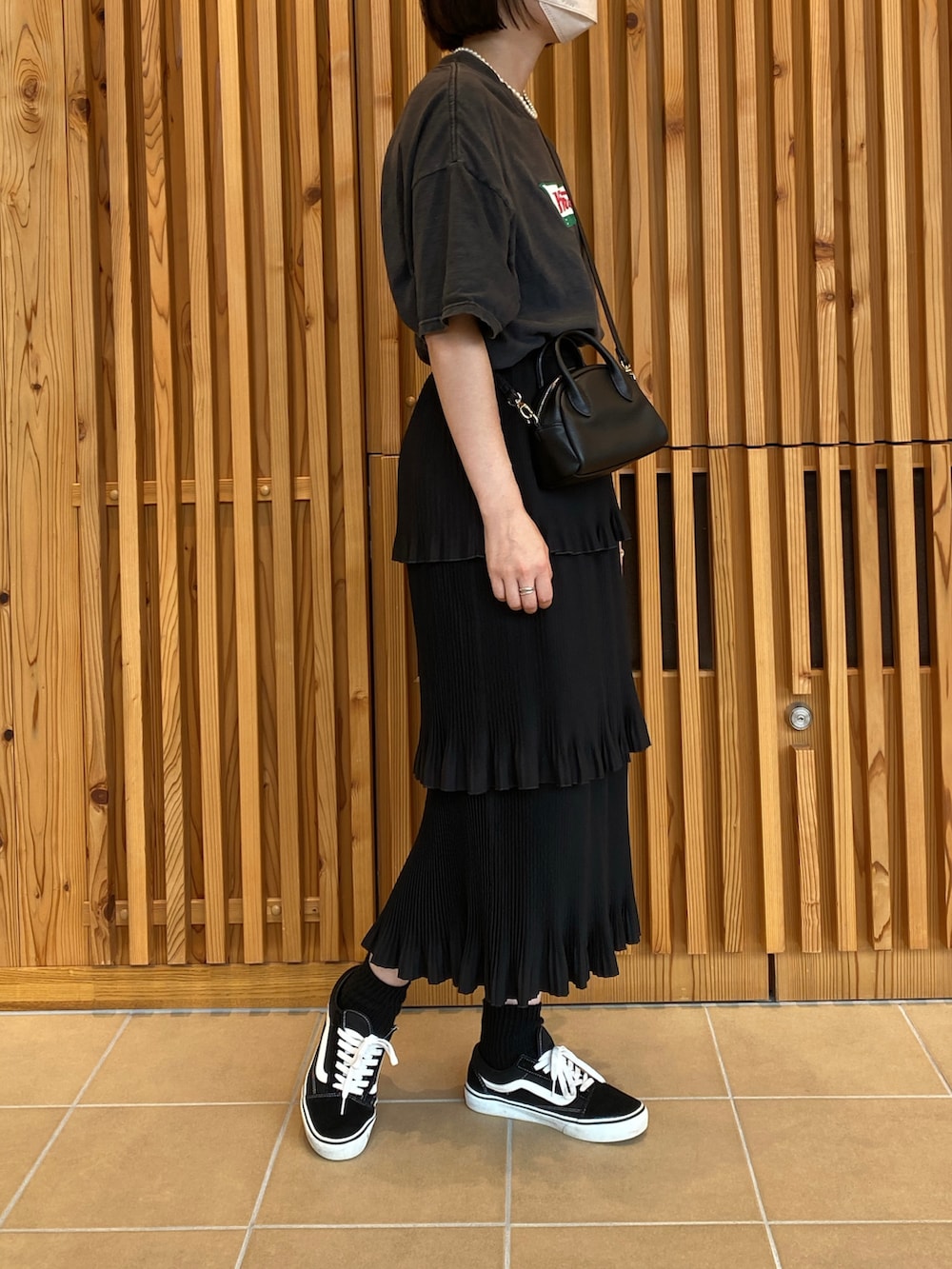 ブラック系のTシャツ/カットソー、ブラック系のスカート、ブラック系のスニーカーを着用したレディースの秋コーディネートの3枚目の写真