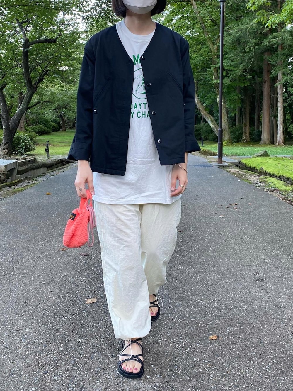 ホワイト系のTシャツ/カットソー、ホワイト系のパンツ、ブラック系のサンダルを着用したレディースの夏コーディネートの3枚目の写真