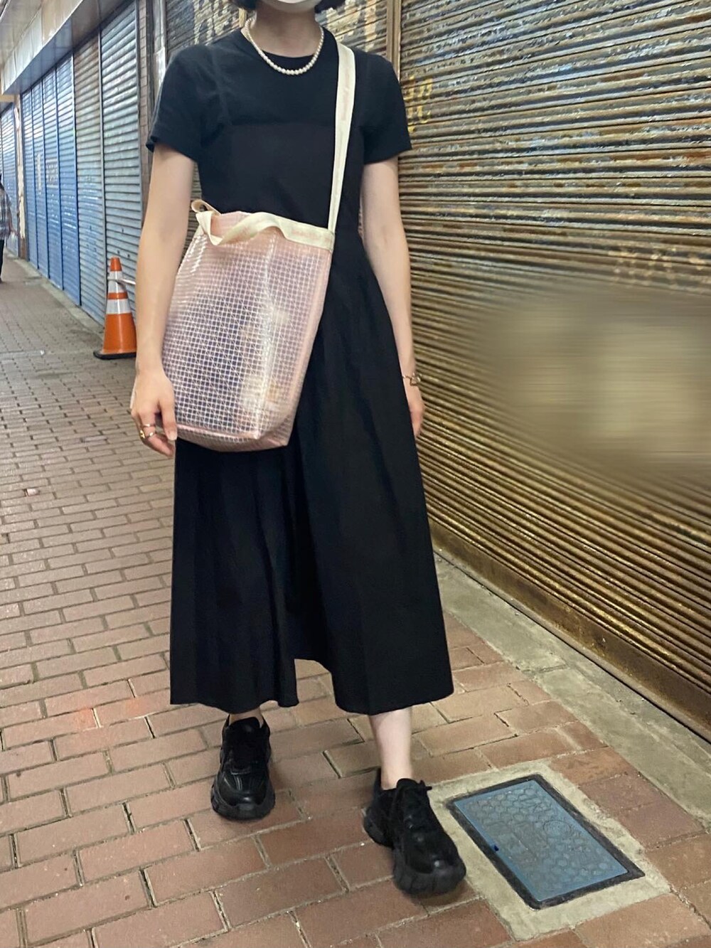 ピンク系のショルダーバッグ、ブラック系のTシャツ/カットソー、ブラック系のドレスを着用したレディースの夏コーディネートの3枚目の写真