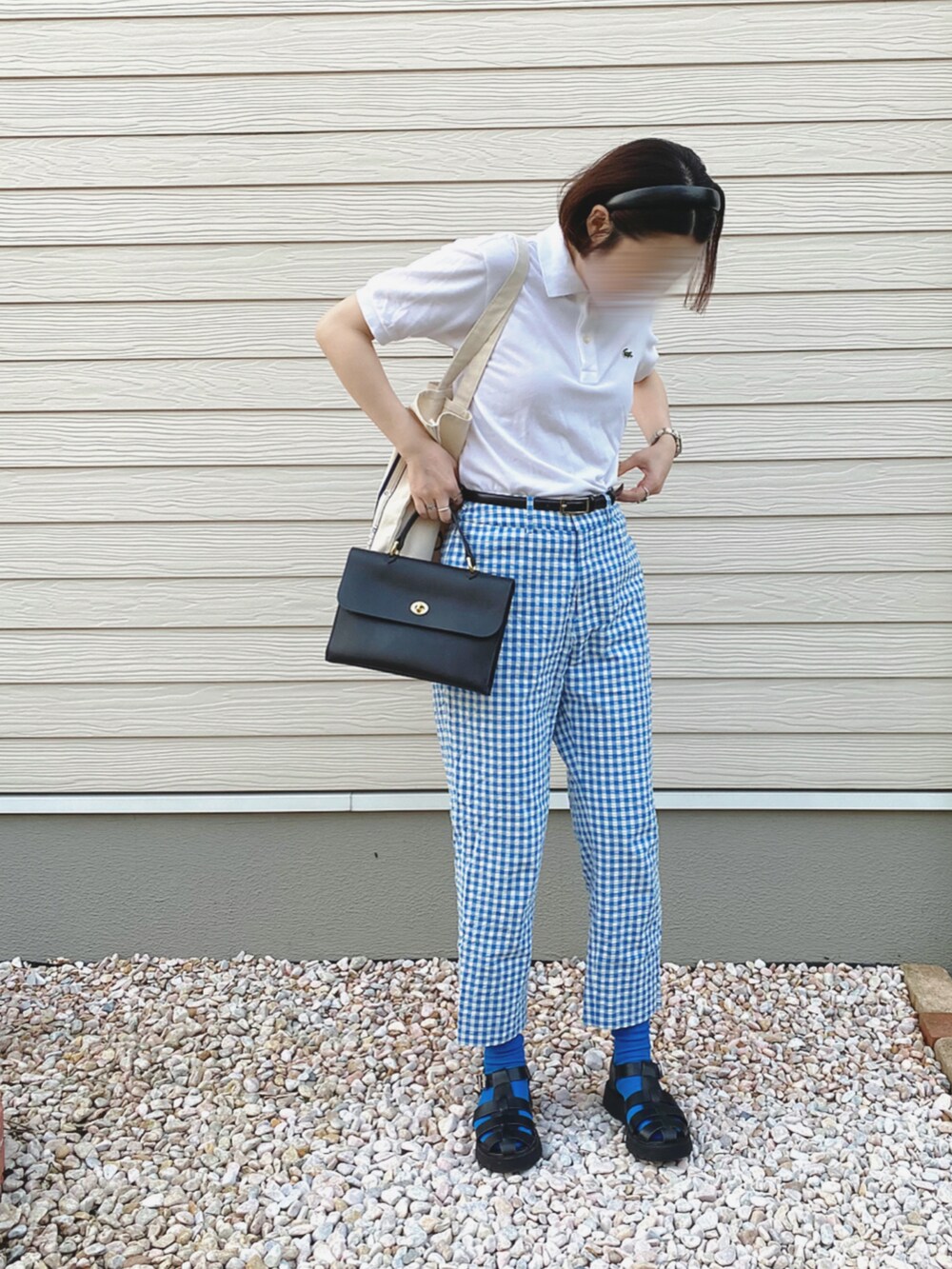 ホワイト系のポロシャツ、ブルー系のその他パンツ、ブラック系のショルダーバッグを着用したレディースの春コーディネートの4枚目の写真