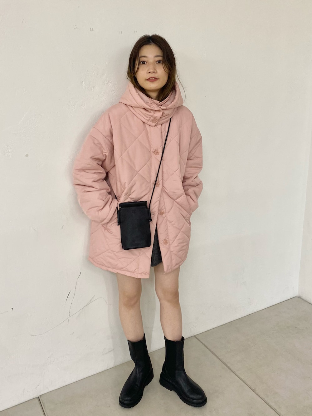 ブラック系のブーツ、ピンク系のダウンジャケット/コートを着用したレディースの秋コーディネートの2枚目の写真
