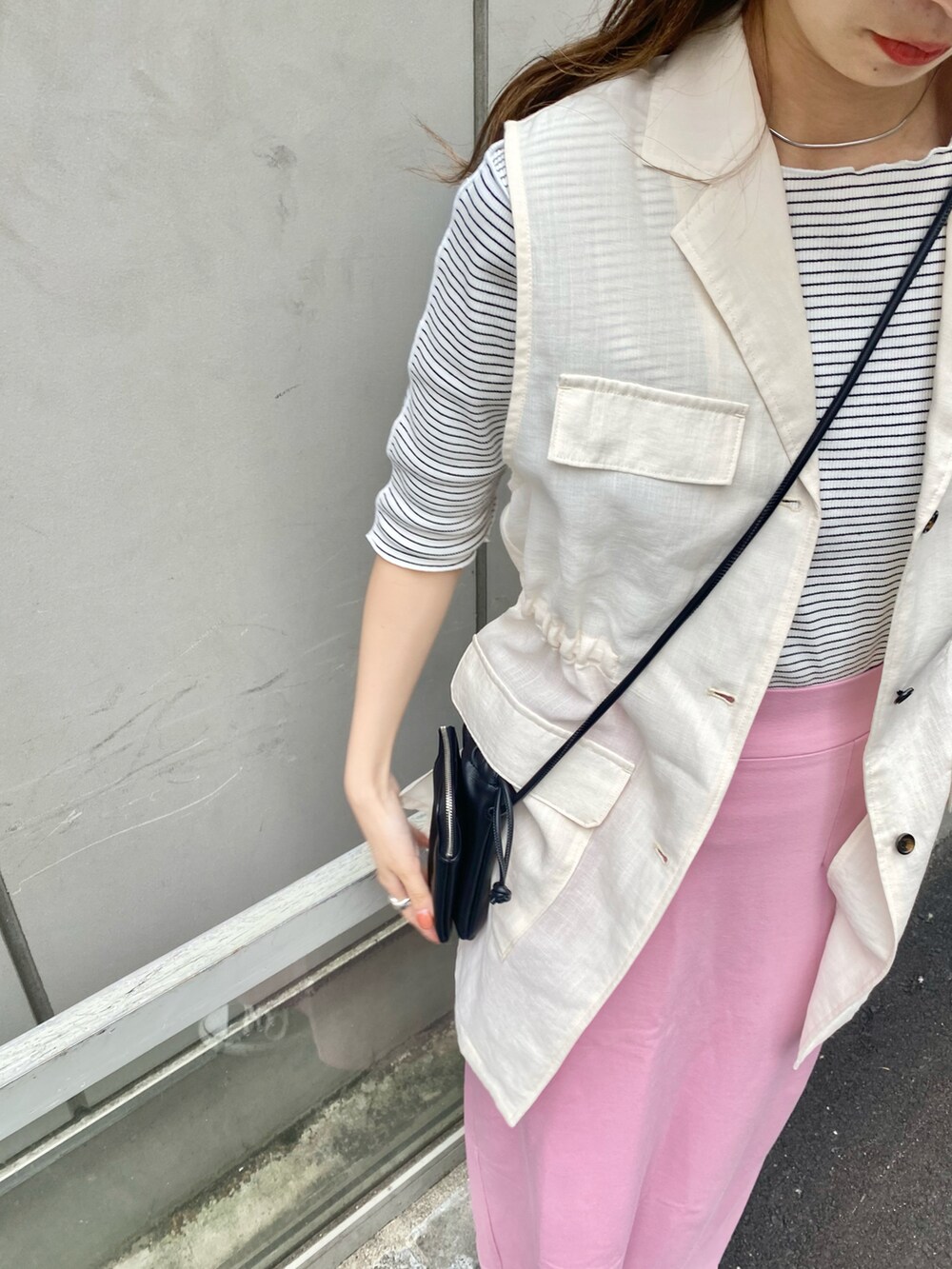 ピンク系のスカート、ホワイト系のベスト、ホワイト系のTシャツ/カットソーを着用したレディースの春コーディネートの4枚目の写真